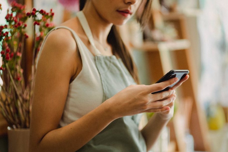 Une commerçante vérifie les horaires de sa boutique
